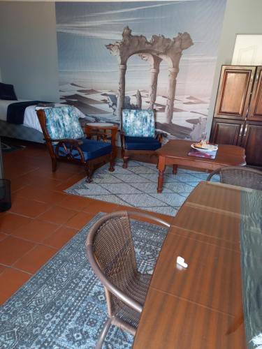 波罗瓜尼Beit-El BnB的客厅配有椅子、桌子和床