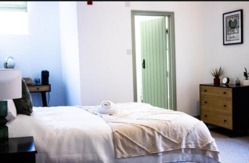 金斯林The White Hart的卧室配有白色的床和绿门