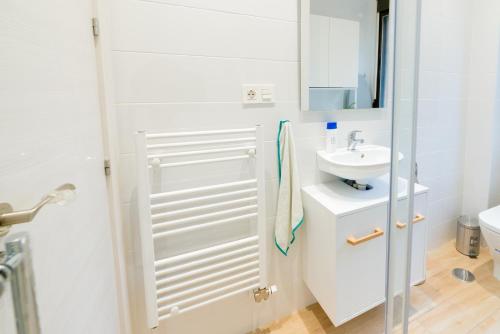 格拉纳达TrendyHomes Granada - moderno apartamento a 15 minutos del centro的白色的浴室设有水槽和镜子
