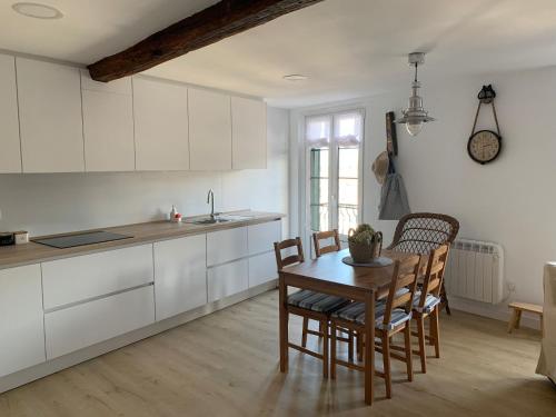 贝梅奥ISTUA - Etxie La Casa的厨房配有白色橱柜和桌椅