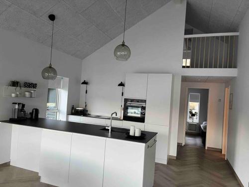 HvalvíkBrandnew Waterfront Apartment的厨房配有白色橱柜和黑色台面