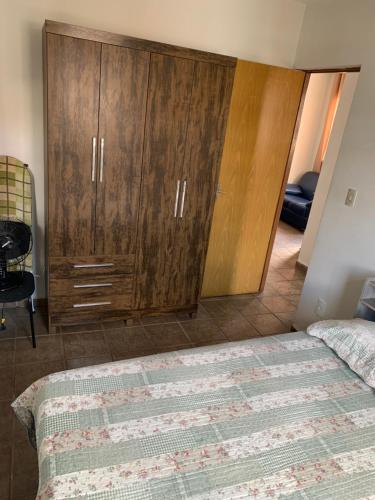 瓦尔任阿Apartamento funcional的一间卧室配有木制橱柜和一张床