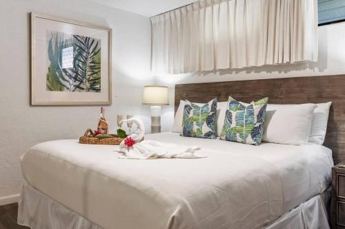 卡哈纳Papakea E206- Updated Papakea oceanview condo, all the amenities的一间卧室配有一张白色大床,床上有鲜花