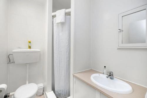 图图卡卡The Sands Motel的白色的浴室设有卫生间和水槽。