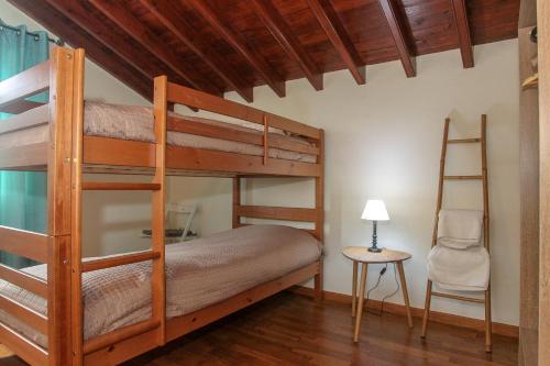 蓬塔德尔加达Capelas Blue , Relax & Fun - Up to 14 Guests!的一间卧室配有两张双层床和椅子