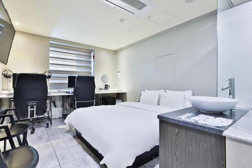 釜山Shire Hotel Seomyeon的卧室配有白色的床和书桌