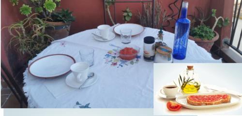 格拉纳达Cute and relaxing bed and breakfast en Albayzín的一张桌子,上面有白色的桌布和盘子