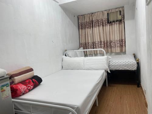 香港Relaince international guest house的小房间设有两张床和窗户