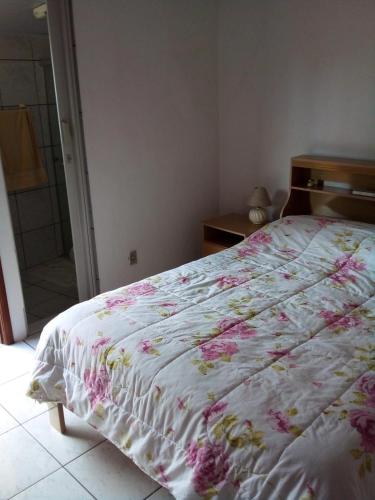 圣若泽杜斯坎普斯Casa SFX Centro的一间卧室配有一张带花卉棉被的床