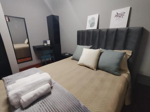 科恰班巴La Casona Hostel的一间卧室配有一张带黑色床头板和枕头的床。