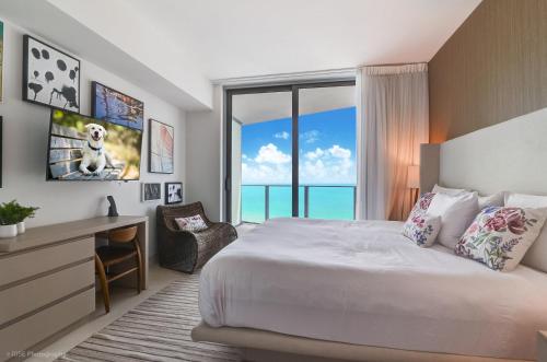 好莱坞Luxurious 2 bedroom on the Ocean IL的一间卧室配有一张床、一张书桌和一个窗户。
