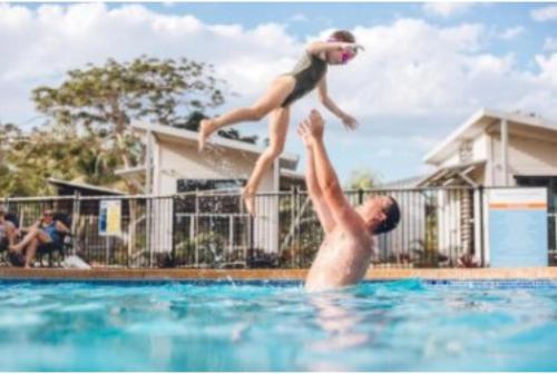 布鲁姆Discovery Parks - Broome的男人和孩子跳入游泳池