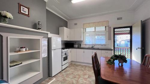 苏塞克斯入口Cosy & Coastal Cottage的厨房配有木桌和冰箱。