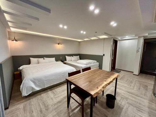 庆州Series hotel的一间卧室设有两张床和一张木桌