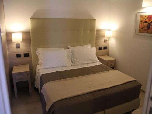 PalagianelloLa Papagna Dimora Storica的一间卧室配有一张带2个床头柜的大床