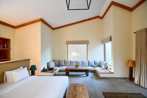 斋浦尔Anopura Jaipur的一间卧室配有一张大床和一张沙发