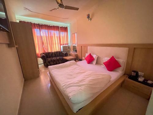 贾姆穆Hotel Himgiri Pakki Daki的一间卧室配有一张带两个红色枕头的床