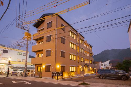 由布市旅の宿 花景色 Tabi no yado Hanageshiki的街道上的建筑物,前面有停车位