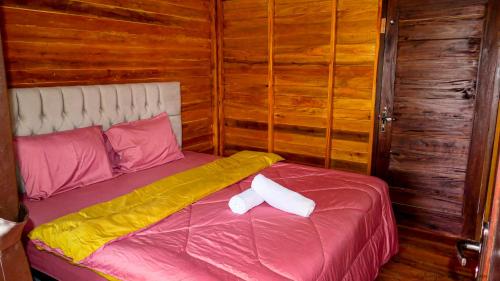 龙目岛库塔Mandalika Queen Hostel的一间卧室配有一张带两个枕头的床