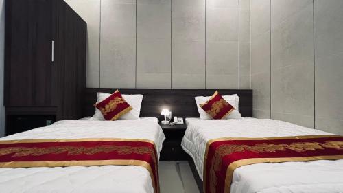 潘切Huy Hoàng Hotel的客房设有两张床和一张带蜡烛的桌子。