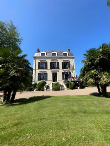圣帕瓦克Domaine de la Belvaudière - luxueux - 24H du Mans - 20p - Rêve au Mans的一座大型白色房子,前面有棕榈树