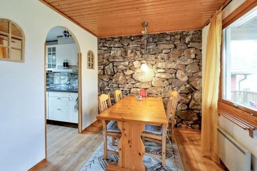 海斯勒霍尔姆Minnebo stuga的一间设有木桌和石墙的用餐室