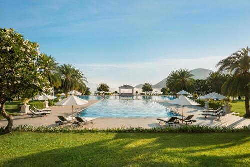 芽庄Nha Trang Marriott Resort & Spa, Hon Tre Island的度假村内带椅子和遮阳伞的游泳池