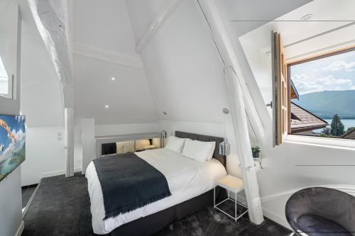 塔卢瓦尔Le Chicissime, coeur du village, LLA Selections by Location lac Annecy的一间卧室设有一张床和一个大窗户