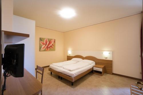 利莫内-苏尔加达Apartments "VILLA IMELDA"的一间卧室配有一张床和一台平面电视