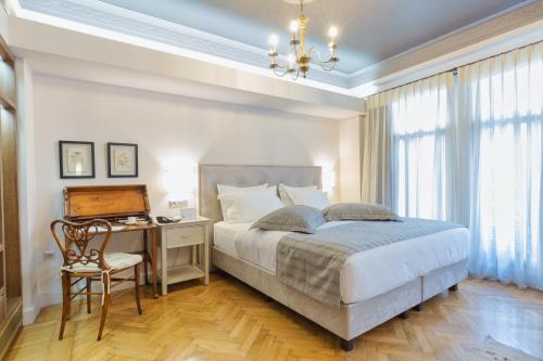 雅典美家园酒店的一间卧室配有一张床和一张带电脑的书桌