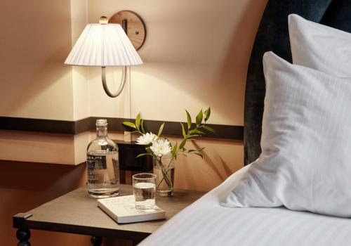 奥斯陆克里斯蒂提特酒店的床上的桌子,上面有一瓶和眼镜