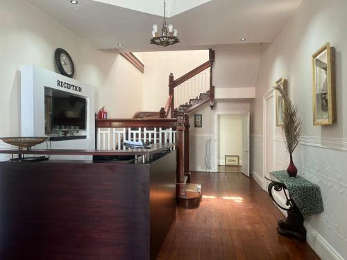 UitenhageHEBA GUEST LODGE的客厅铺有木地板,设有楼梯。
