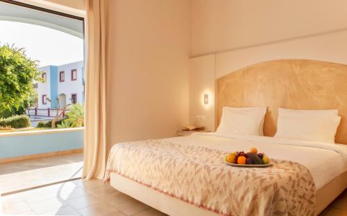 阿林达Hotel Marilen的一间卧室,配有一张床,上面放着一碗水果