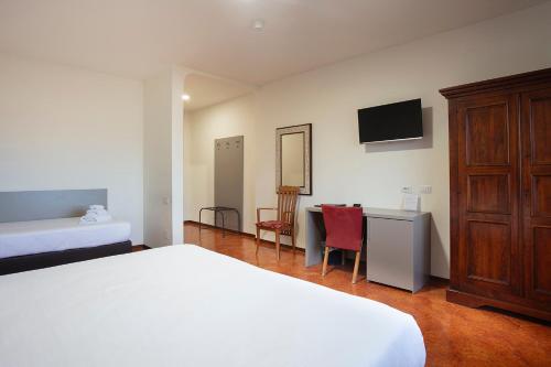 摩德纳CDH Hotel Modena的一间卧室配有一张床和一张书桌及电视