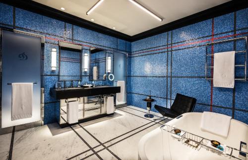 巴库Dinamo Hotel Baku的蓝色的浴室设有浴缸和水槽