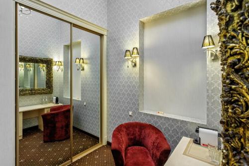 敖德萨Vintage Art Hotel的一间带红色椅子和镜子的浴室