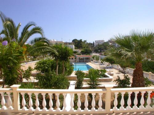 阿林达Hotel Marilen的一个带游泳池和棕榈树的度假村的阳台