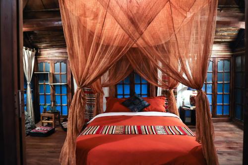 Pu LuongLua Pu Luong的一间卧室配有红色的床和天篷