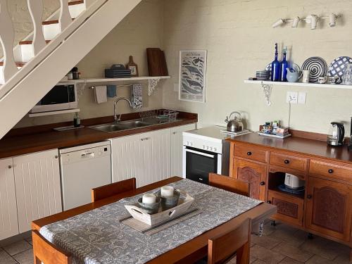 戈登湾By Die See的厨房配有水槽和桌椅