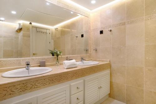 贝纳尔马德纳Luxury in Puerto Marina的一间带两个盥洗盆和大镜子的浴室