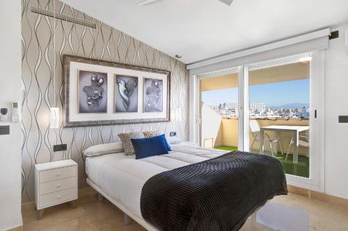 贝纳尔马德纳Luxury in Puerto Marina的一间带大床的卧室和一个阳台