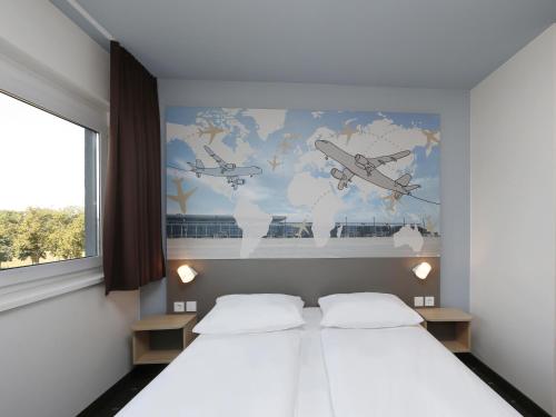 舍讷费尔德柏林机场住宿加早餐酒店的一间卧室设有两张床,并提供一张世界地图