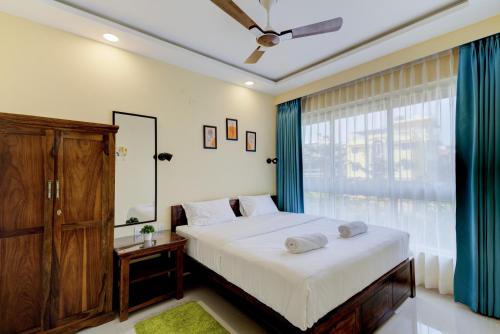 达波林Luxe 2BHK by Coral BnB with Pool access的一间卧室设有一张大床和一个窗户。