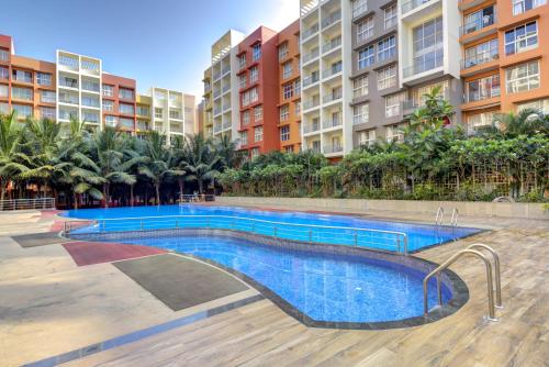 达波林Luxe 2BHK 10min from GOI airport with Pool access的部分公寓大楼前的游泳池