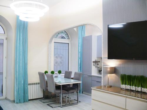 基辅Luxury Centre Located Apartment的一间带桌子和平面电视的用餐室