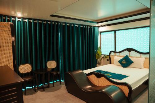 Bắc GiangSky Hotel的一间卧室配有一张带绿色窗帘和椅子的床