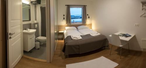 斯普恩萨杜尔哈尼亚尔高地中心旅馆的一间卧室配有一张床,浴室设有水槽