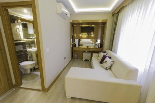 伊斯坦布尔mars hotel的一间带白色沙发的客厅和一间浴室
