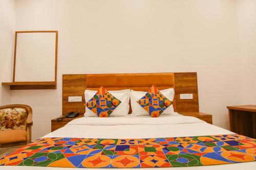 钱德加尔FabHotel Ambassador的一间卧室配有一张带五颜六色棉被的床