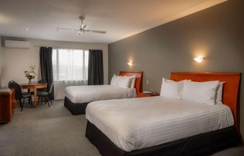 罗托鲁瓦Arawa Park Hotel, Independent Collection by EVT的酒店客房配有两张床和一张书桌